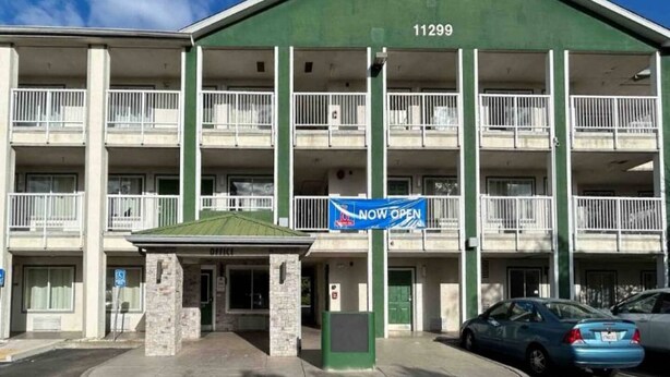 A multi-story building with a green facade, numbered 11299, and a sign indicating it's now open. - 2 Queen Beds|Non-Smoking,Kitchen (Rancho Cordova)