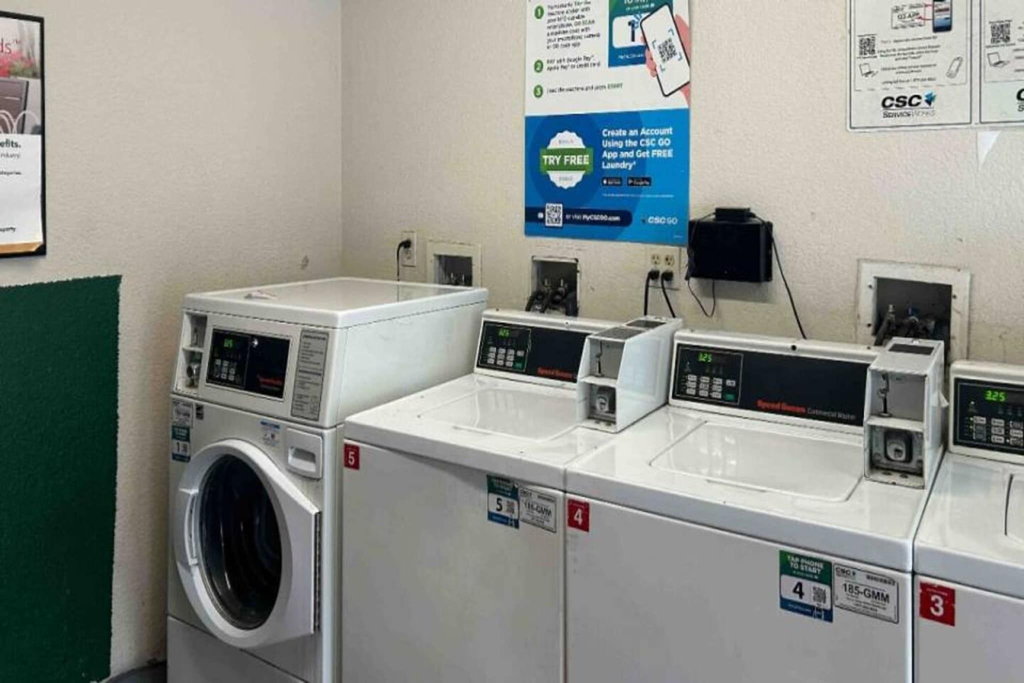 Uma lavanderia com várias máquinas de lavar e secar, cada uma identificada com um número.