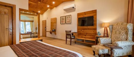 Un dormitorio con cama, una silla, un escritorio y televisión.