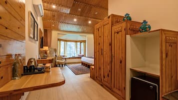 A wooden interior with a kitchen area, a dining table, and a bench.