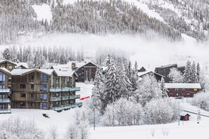A snow-covered lodge with multiple buildings, including a large wooden structure with balconies and a smaller red building. - Mountain apartment in Hemsedal - For skiing and mountain tours (Hemsedal)