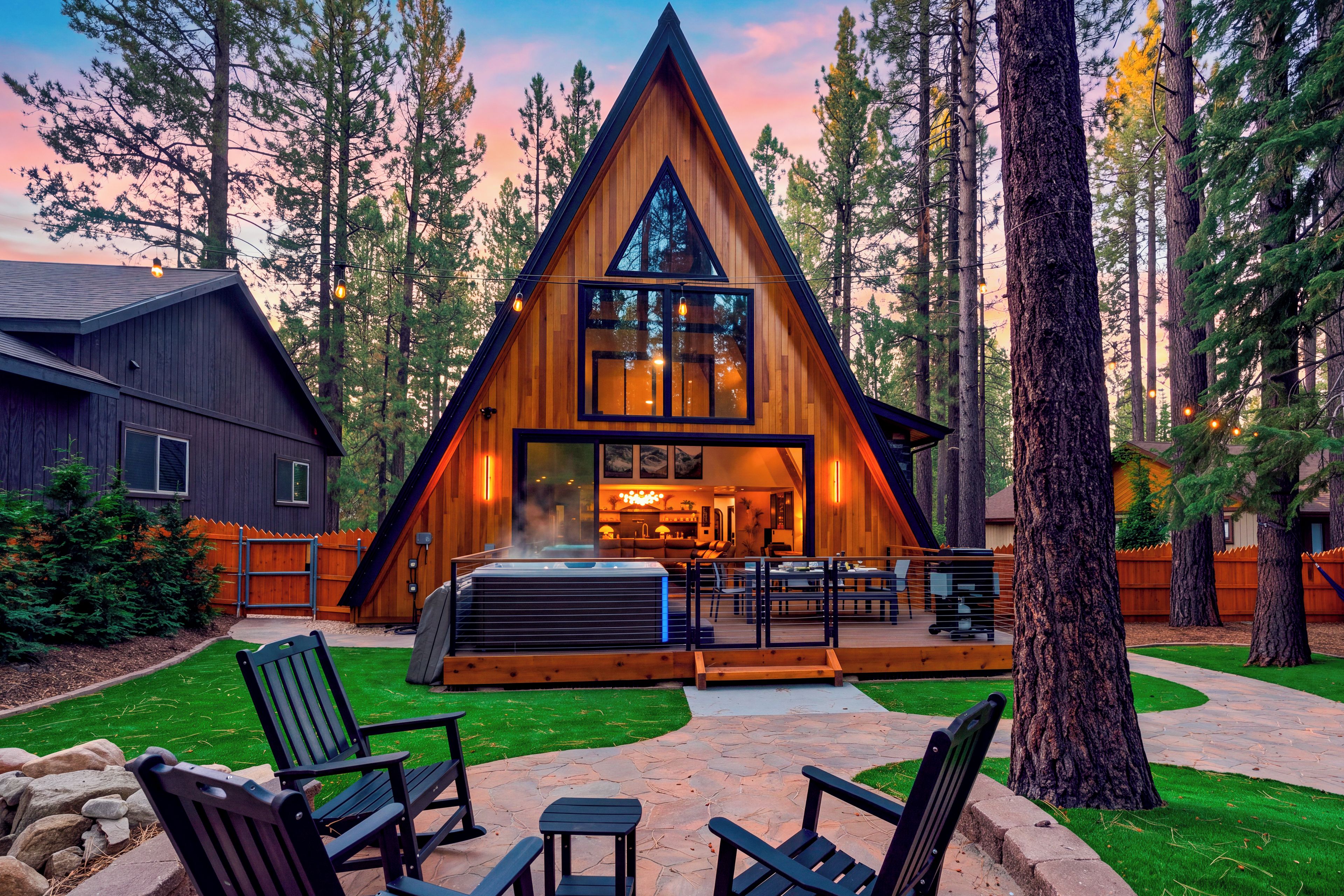 Une cabane en bois dotée d’un bain à remous, d’un espace extérieur aménagé et offrant une vue sur la forêt environnante.