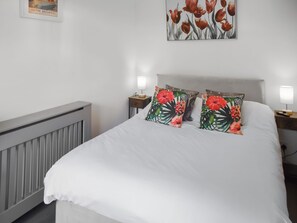 A neatly made bed with white linens, two pillows with a tropical print, a framed picture on the wall, and a bedside lamp on each side. - 2 bedroom accommodation in Repps-with-Bastwick (Repps-with-Bastwick)