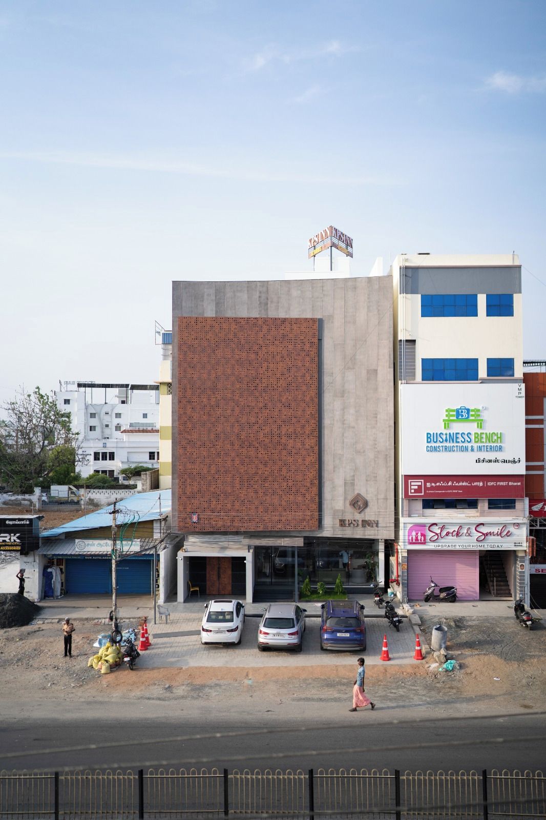 Un immeuble commercial doté d’une grande façade métallique et d’une enseigne indiquant le nom de l’entreprise « Business Bench Construction & Interior ».