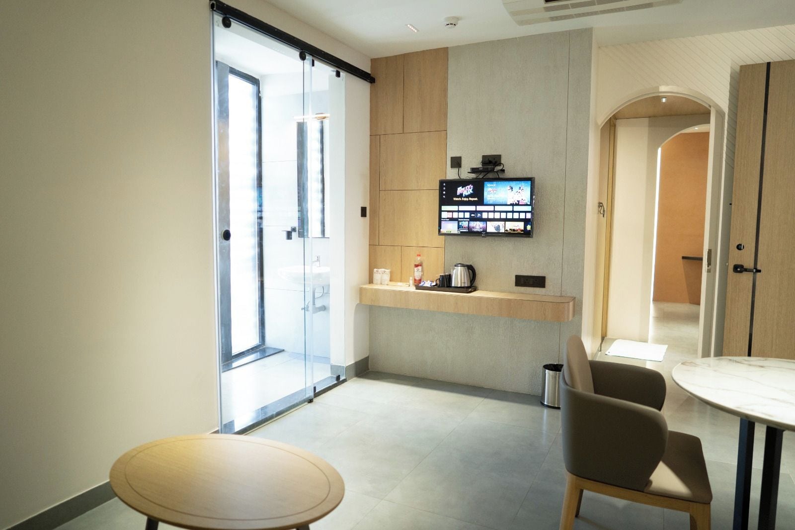 A modern kitchen with a flat-screen TV, a coffee machine, and a small counter.