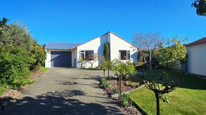 A two-story house with a garage, a driveway, and a well-maintained lawn. - Holiday Haven, a real family getaway (Richmond)