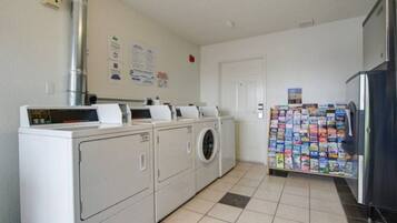A laundry room with a washing machine, dryer, and a refrigerator.