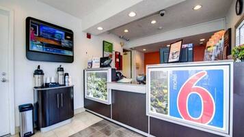 A reception area with a television, a trash bin, and a sign indicating the number 6.