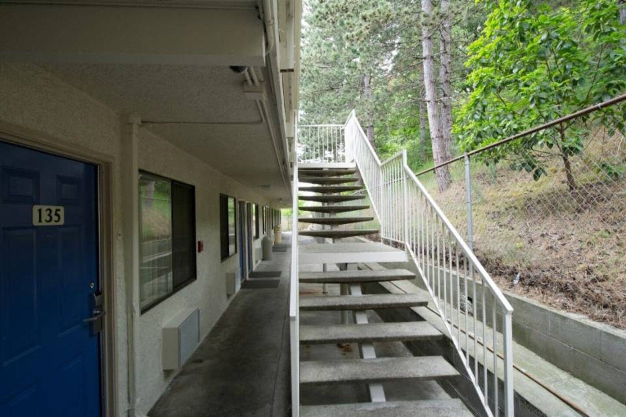 A building with a blue door marked '135' and a staircase leading to an upper level.