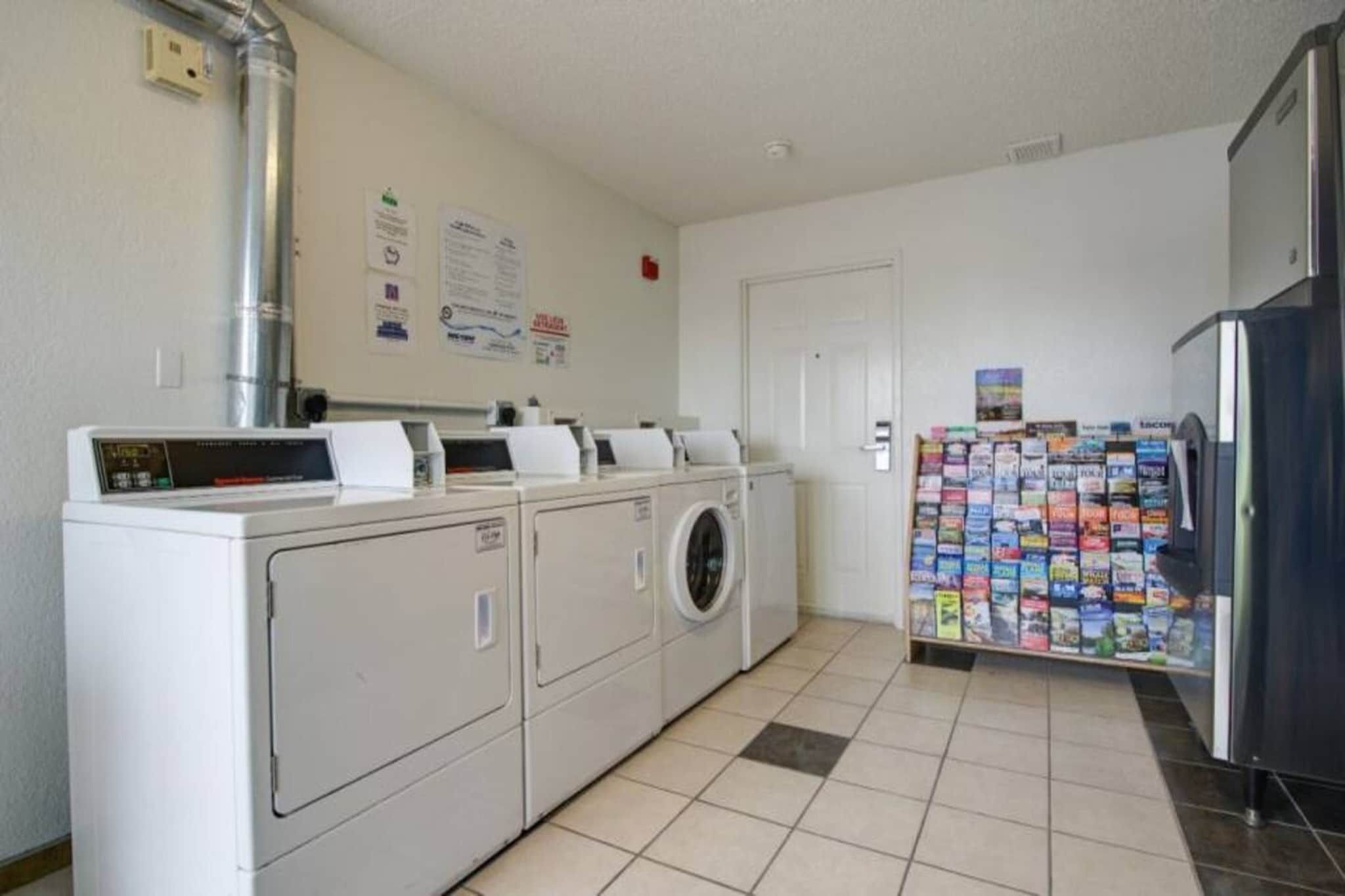 A laundry area with a washing machine, dryer, and a refrigerator.