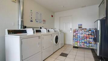 A laundry area with a washing machine, dryer, and a refrigerator.