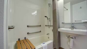Une salle de bain avec une baignoire, une douche et un lavabo.