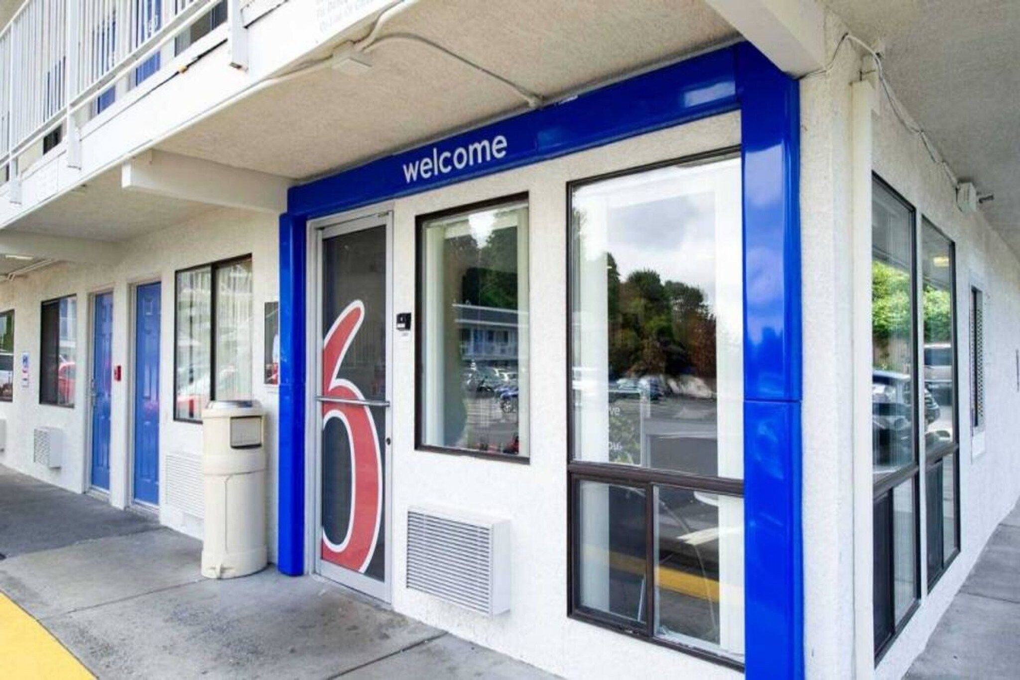 A building with a blue and white facade, a large number '6' sign, and a 'welcome' sign above the entrance.