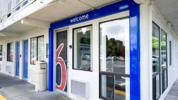 A building with a blue and white facade, a large number '6' sign, and a 'welcome' sign above the entrance.