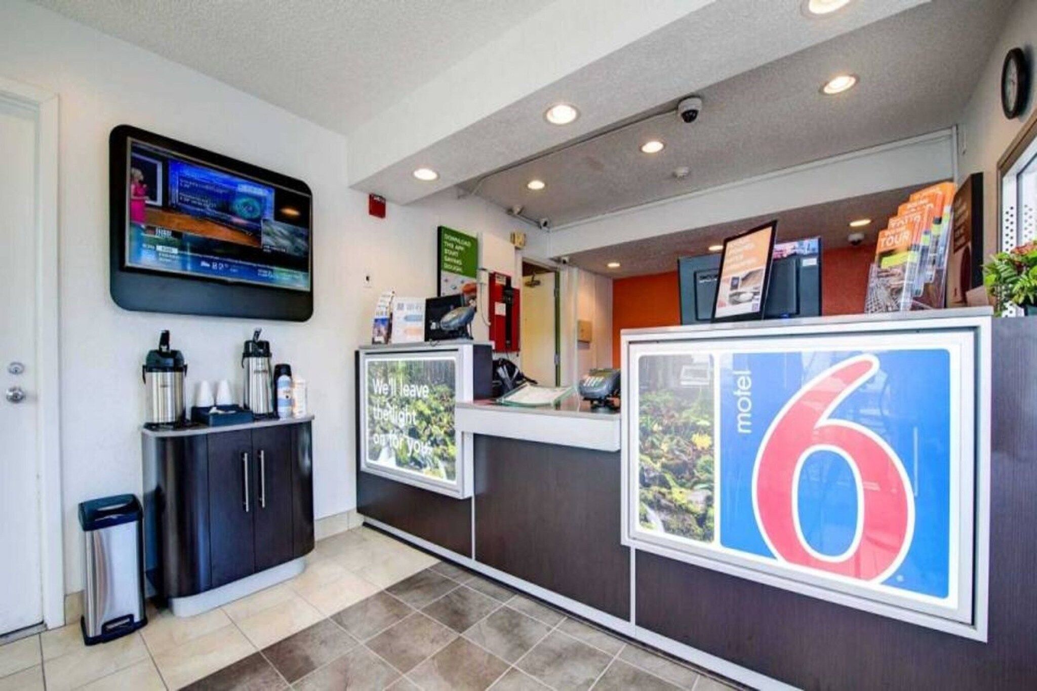 A reception area with a television, a trash bin, and a sign indicating the number 6.