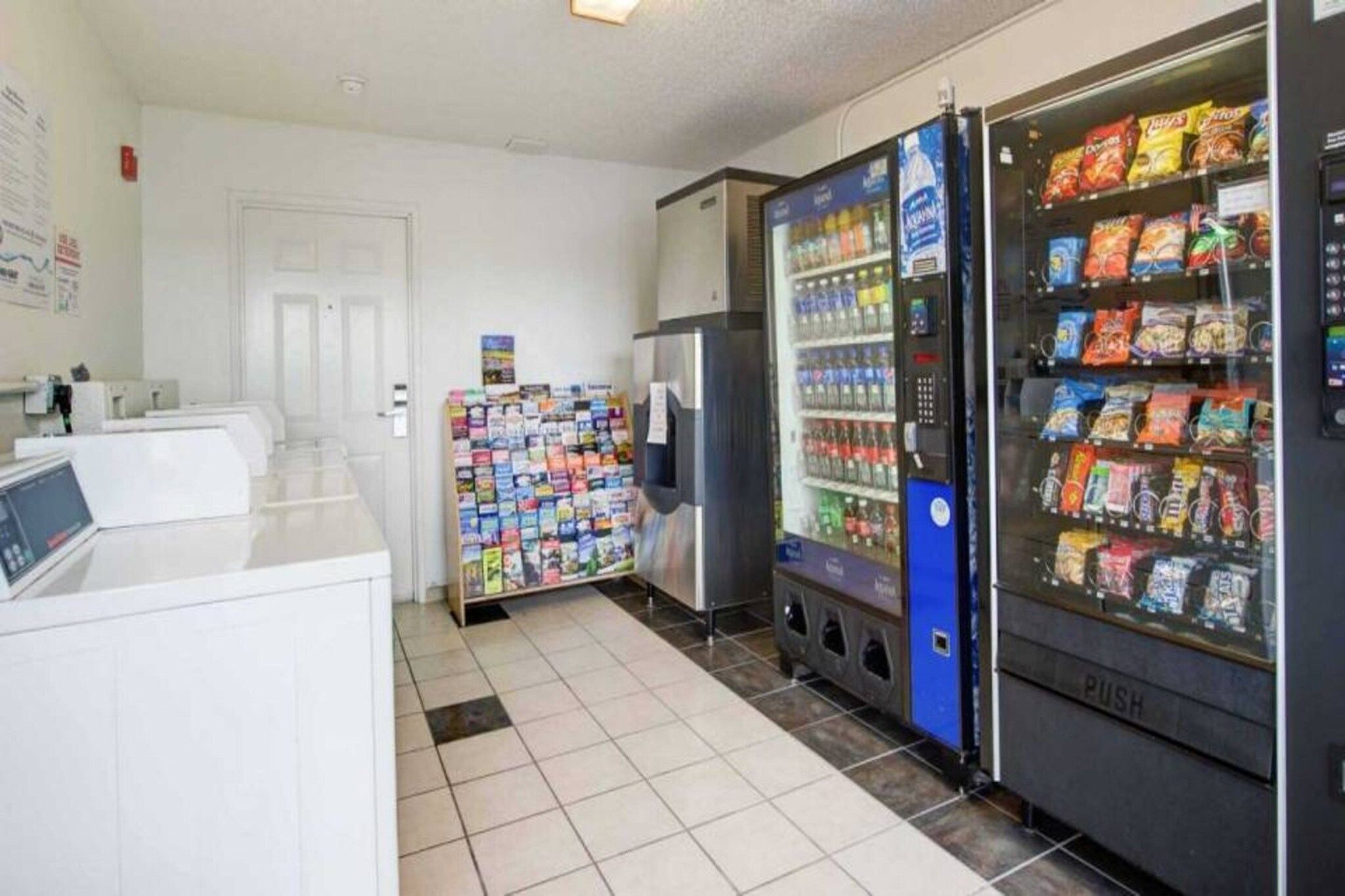 A vending machine area with snacks and beverages, a refrigerator, and a magazine rack.