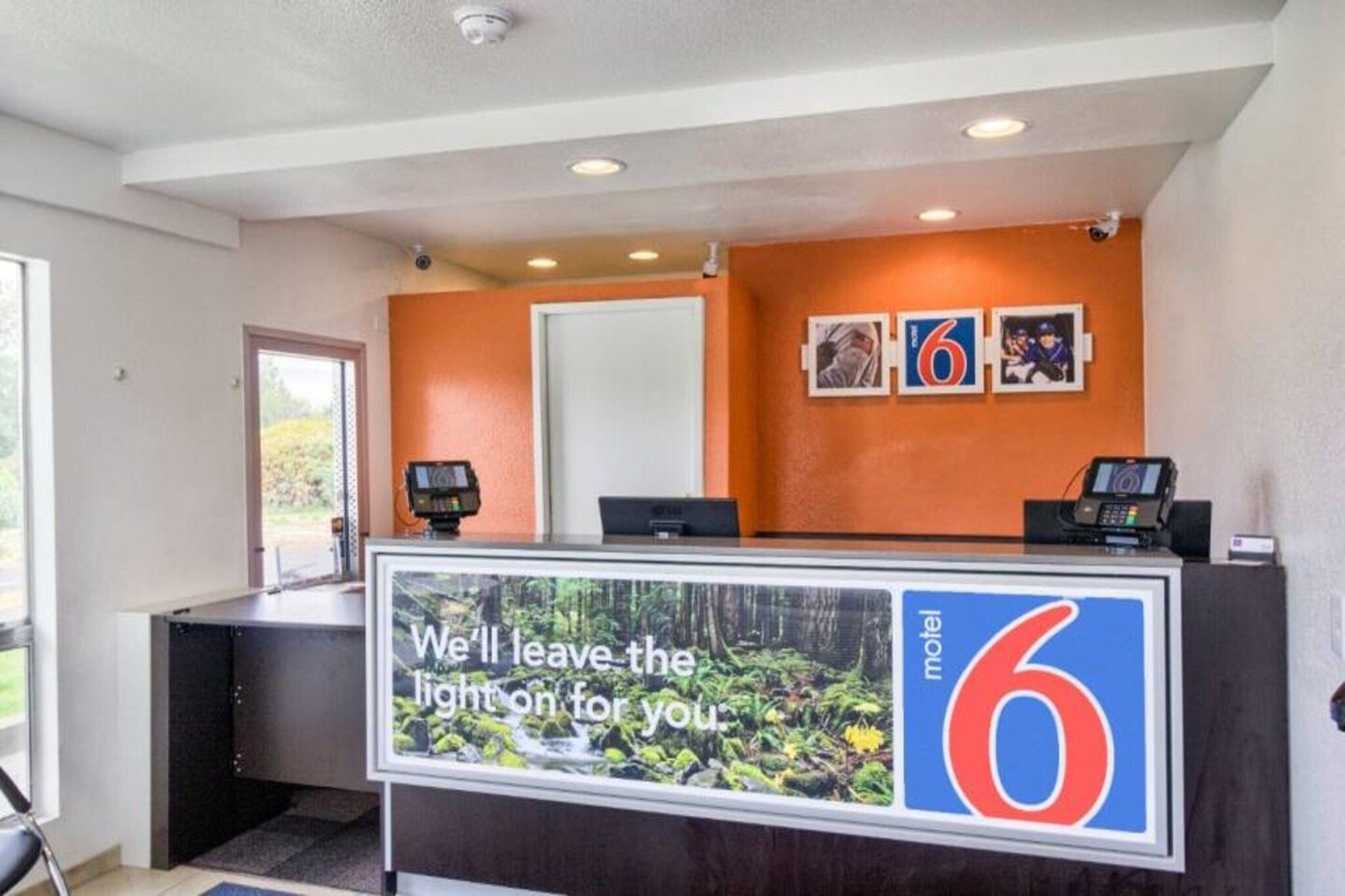 A hotel reception desk with a sign that reads 'We'll leave the light on for you.'