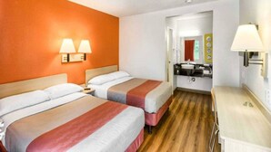 A hotel room with two beds, a desk, and a bathroom visible through an open door. - 2 Full Beds | Non-Smoking (Everett)