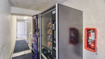 Un corridoio con distributori automatici e un estintore fissato al muro.