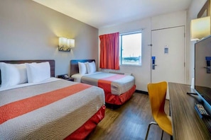 A hotel room with two beds, a desk, a chair, a window with curtains, and a door. - 2 Queen Beds|Micfridge (Santa Rosa NM)