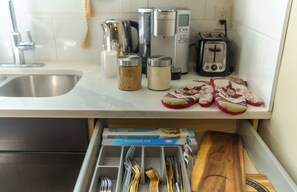 Een keukentafel met een broodrooster, waterkoker en een pak aluminiumfolie.