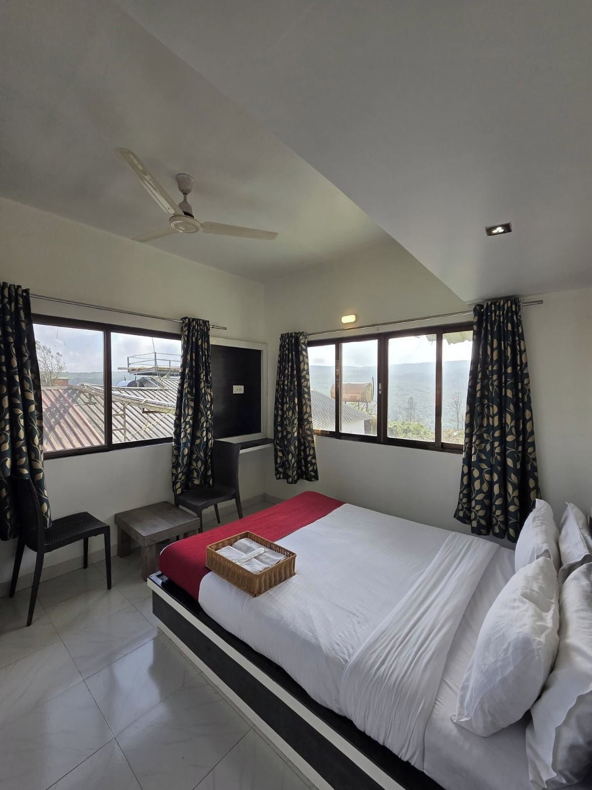 A hotel room with a bed, a desk, a chair, and a television.