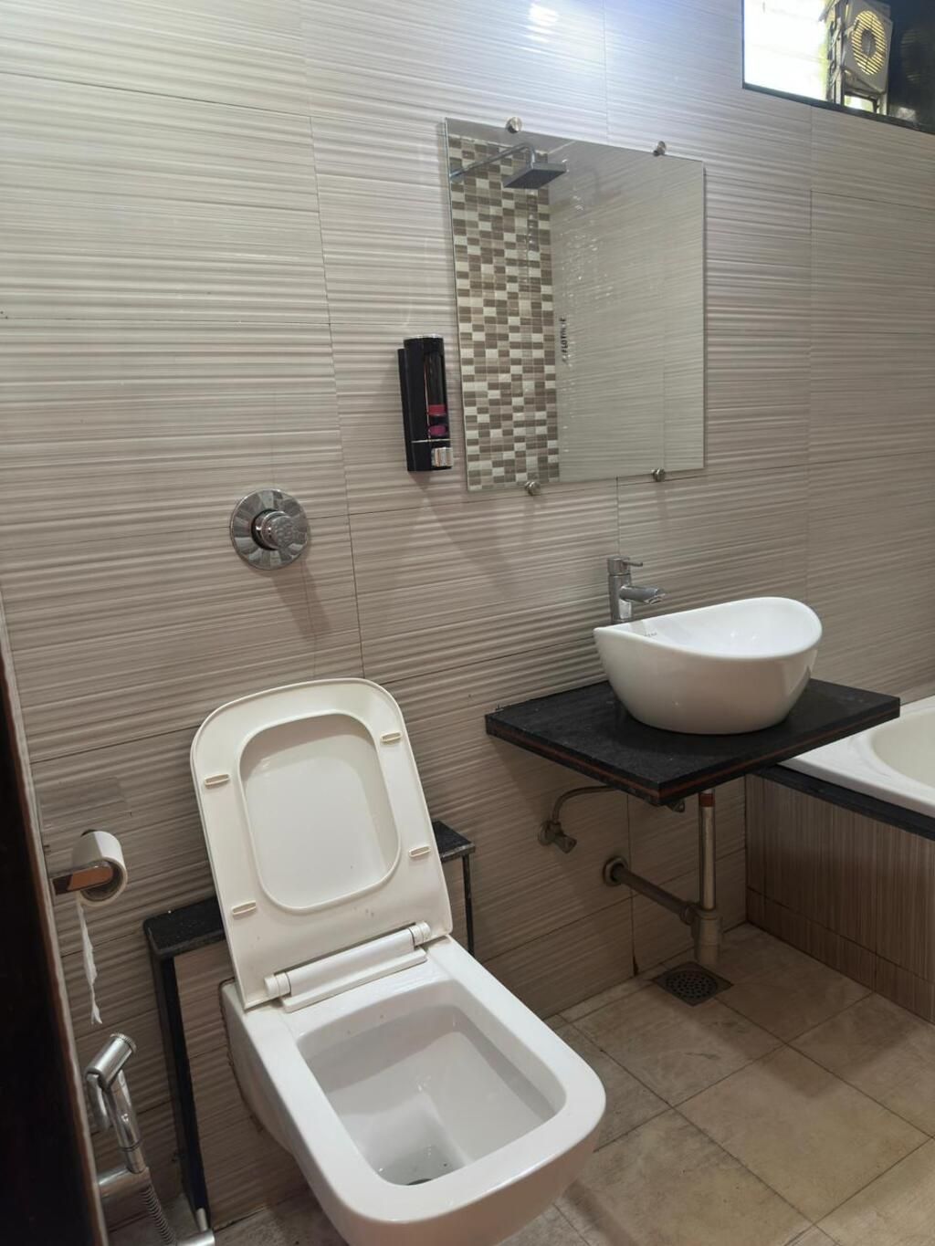 Une salle de bain avec des toilettes, un lavabo et un miroir.