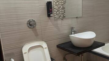 Une salle de bain avec des toilettes, un lavabo et un miroir.