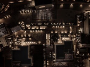 An aerial view of a hotel with multiple floors, interconnected balconies, and outdoor lighting. - Enigma Mykonos Hideaway Suites (Mykonos)