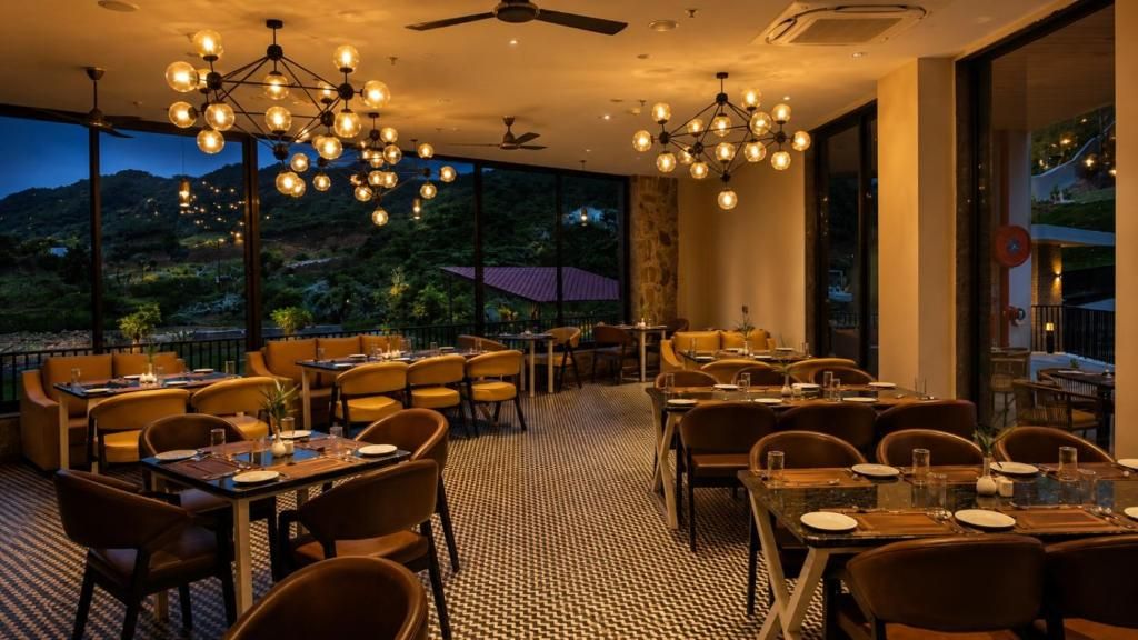 Un restaurante con mesas y sillas, piso estampado y vistas al exterior.