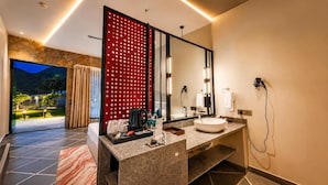 A modern bathroom with a large mirror, a sink, and a hairdryer. - Ullasa by Aranyam  Luxury Resort Udaipur (udiapur)