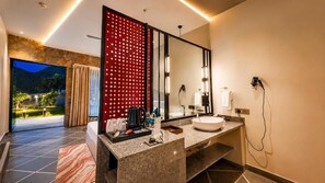 Un baño moderno con un espejo grande, un lavamanos y un secador de pelo.