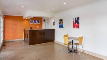 A reception area with a counter, two chairs, and a tiled floor.