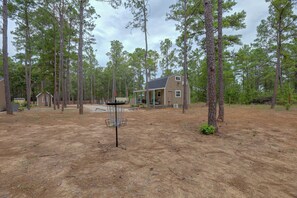 Ein Wohngebiet mit einem Haus, einem Discgolf-Korb und umliegenden Bäumen.