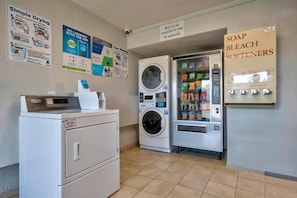 A laundry area with a washing machine, dryer, and a soap and bleach softener dispenser. - 1 Full Bed | ADA/Tub (Albuquerque)