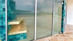 Um edifício moderno com amplas portas de vidro e fachada revestida de azulejos.