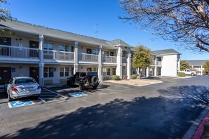 A multi-story motel with parking spaces, including a handicapped accessible spot.