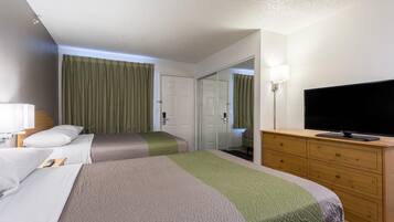 A hotel room with two beds, a television, a dresser, and a mirror.
