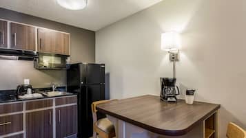 A compact kitchenette with a refrigerator, microwave, and coffee maker.