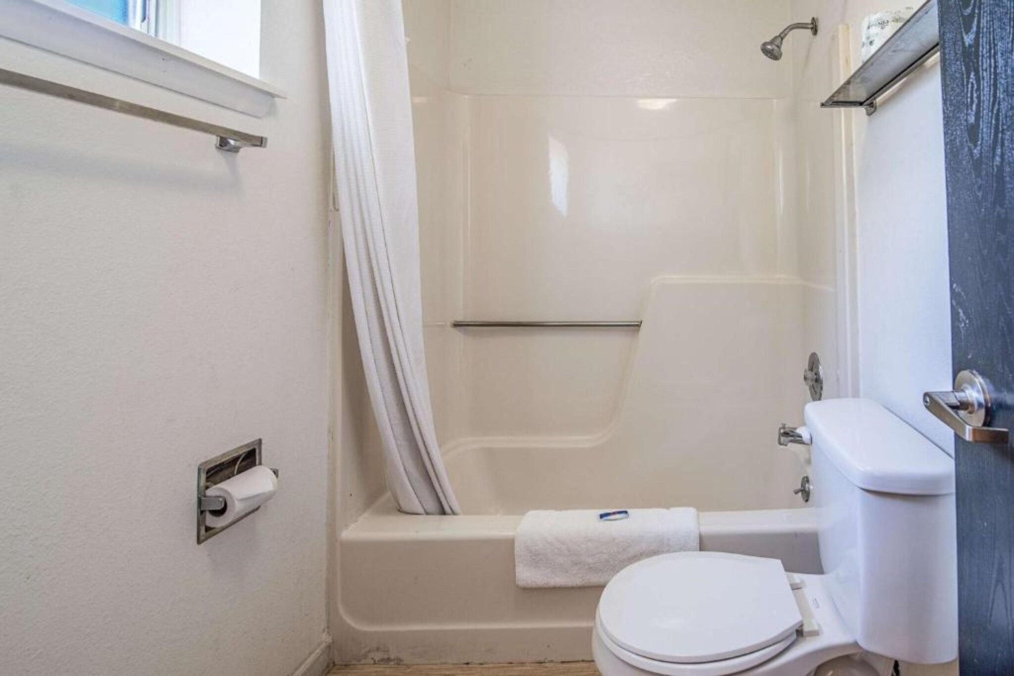 Une salle de bain comprenant des toilettes, une baignoire et une douche.