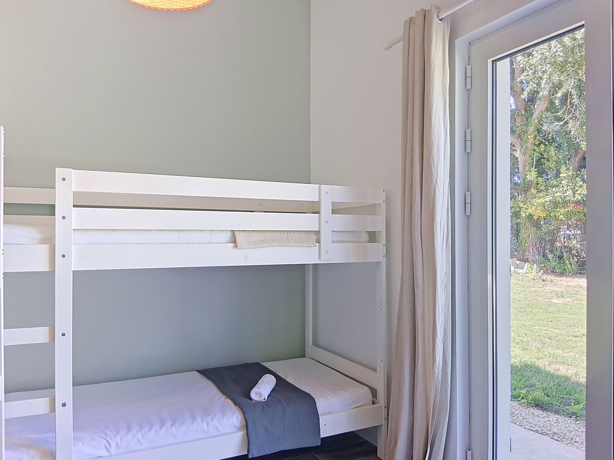 Ein Etagenbett mit einem kleinen Tisch und einem Fenster mit Vorhängen.
