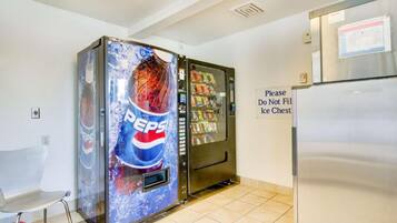 Una máquina expendedora con publicidad de Pepsi y un refrigerador.