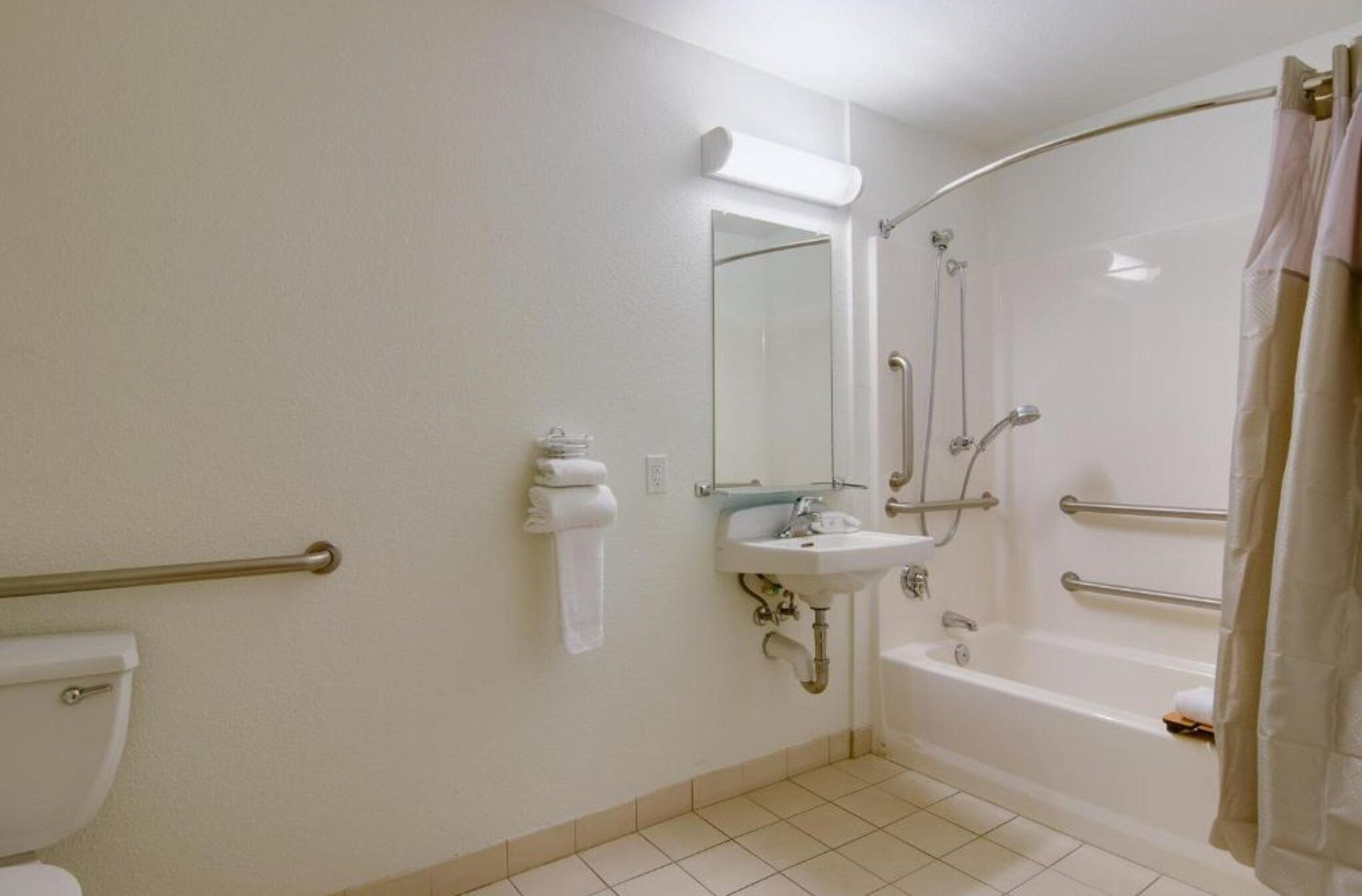 A bathroom with a toilet, sink, and shower area.