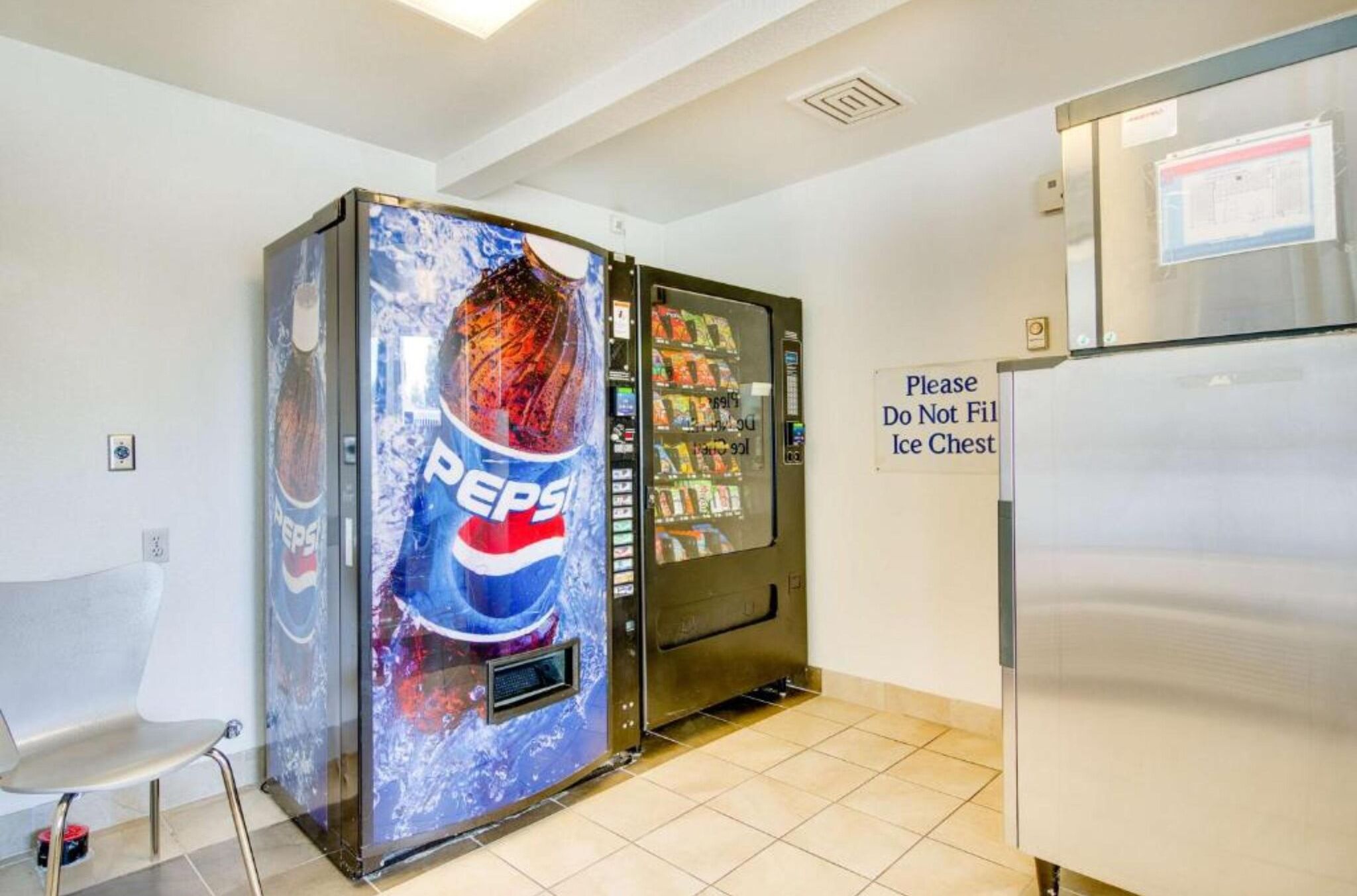 Ein Getränkeautomat mit einer Pepsi-Werbung und einem Kühlschrank.