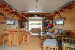Een blokhutinterieur met een bar, zitgedeelte en uitzicht op de omgeving.