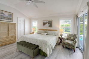 A bedroom with a large bed, a chair, a wardrobe, and a window with a view of greenery. - < 1 Mi to Spanish Springs! Extended Stay w/ Pool (The Villages)