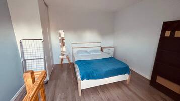 A bedroom with a bed, bedside table, and a chair.
