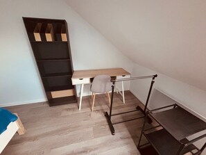 Une pièce comprenant un bureau, une chaise et une bibliothèque.