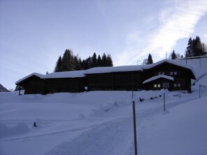 A wooden lodge with a snow-covered roof, surrounded by trees and a snowy landscape. - Maiensäss Cavadürli Appartement/Fewo, Dusche oder Bad, WC 5-Zimmerwohnung by Interhome (Klosters)