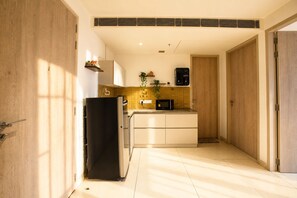 Eine kleine Küche mit Kühlschrank, Mikrowelle und einer Arbeitsplatte.